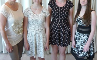 Vier Personen stehen nebeneinander. Eine Frau und drei junge Frauen in unterschiedlicher Kleidung.