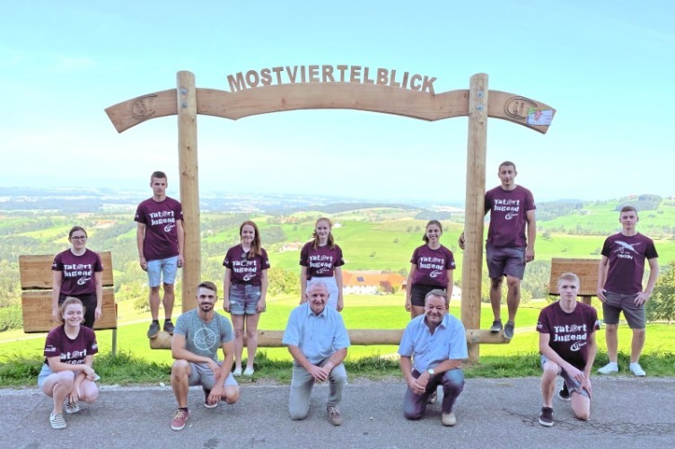 Gruppe von Personen in T-Shirts vor einer grünen Wiese.