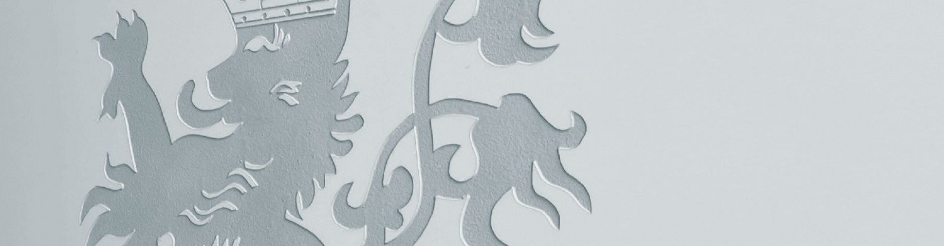 Wappen mit Löwenkopf und Flammen, graviert in grauen Farbe