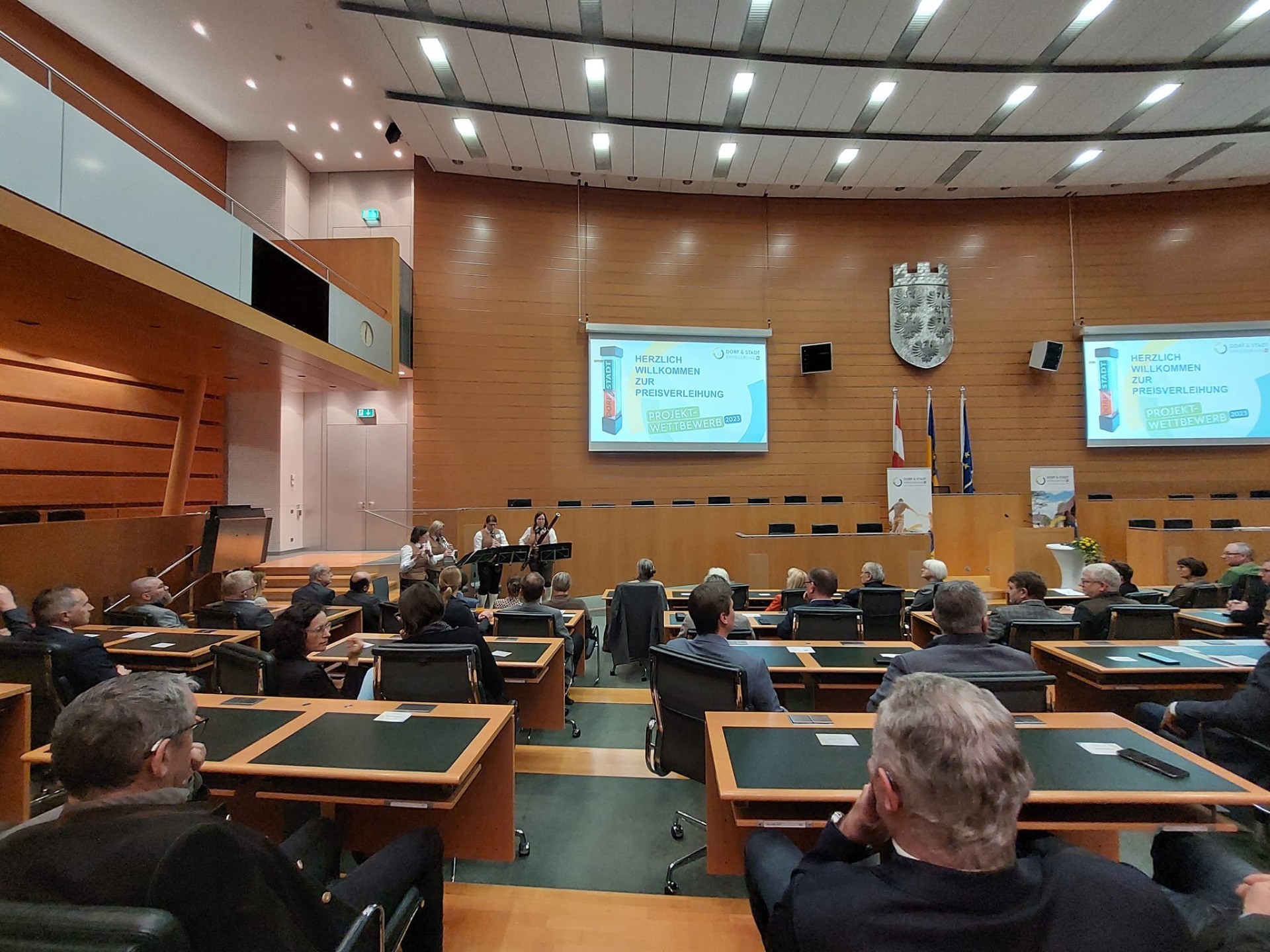 Gesprichsaal mit zahlreichen Personen, die zu einem Sitzungssaal hin sitzen.