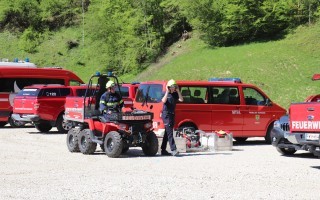 Feuerwehrfahrzeuge in einer Reihe, darunter ein geländegängiger Traktor, und ein Einsatzfahrzeug.