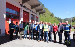 Freiwilige der Freiwilligen Feuerwehr Opponitz stehen vor einem roten Feuerwehrhaus. Einige tragen Warnweste.