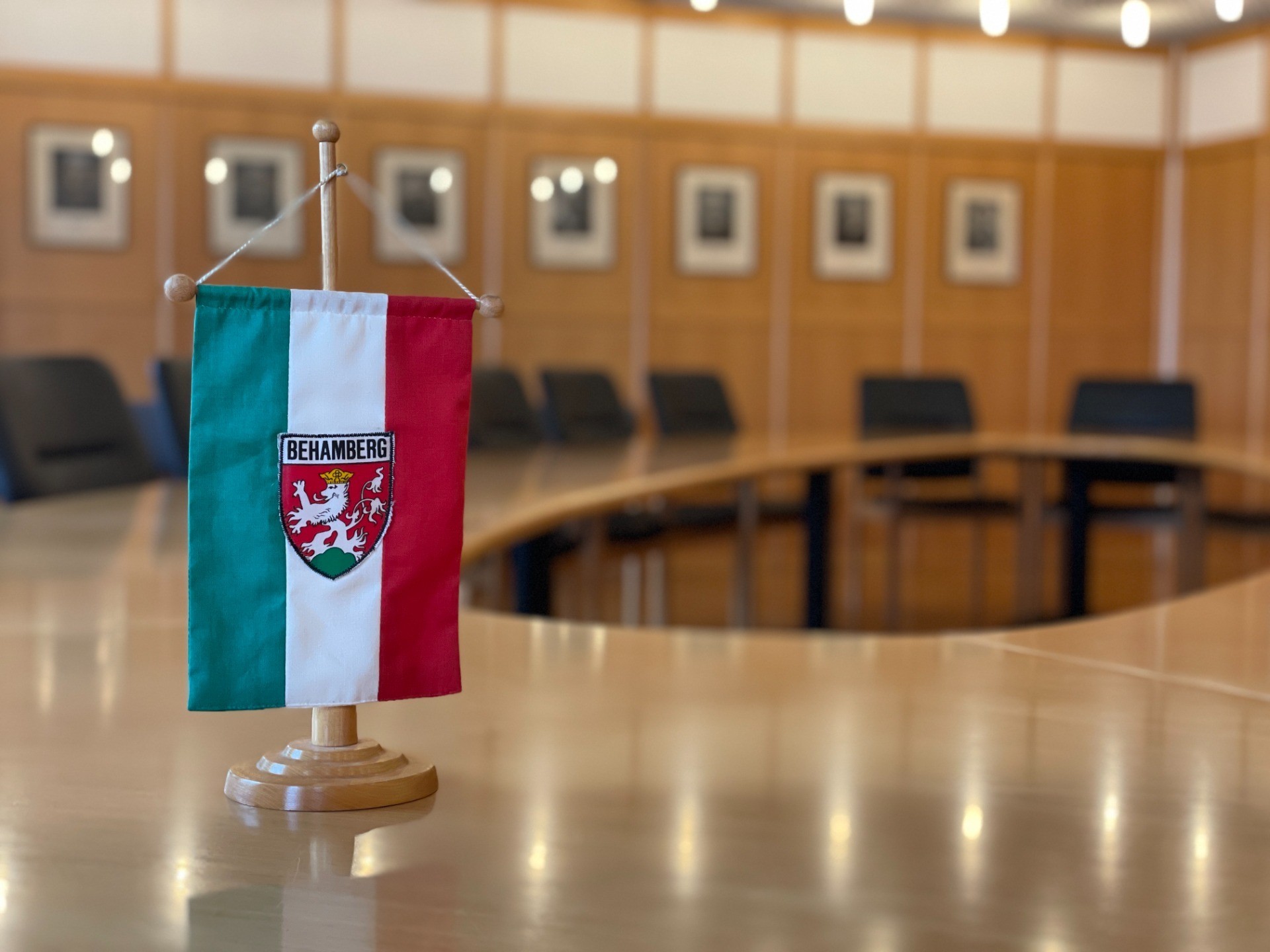 Ungarisches Wappen auf Sockel, Sitzungsraum mit Rundbanken im Hintergrund.