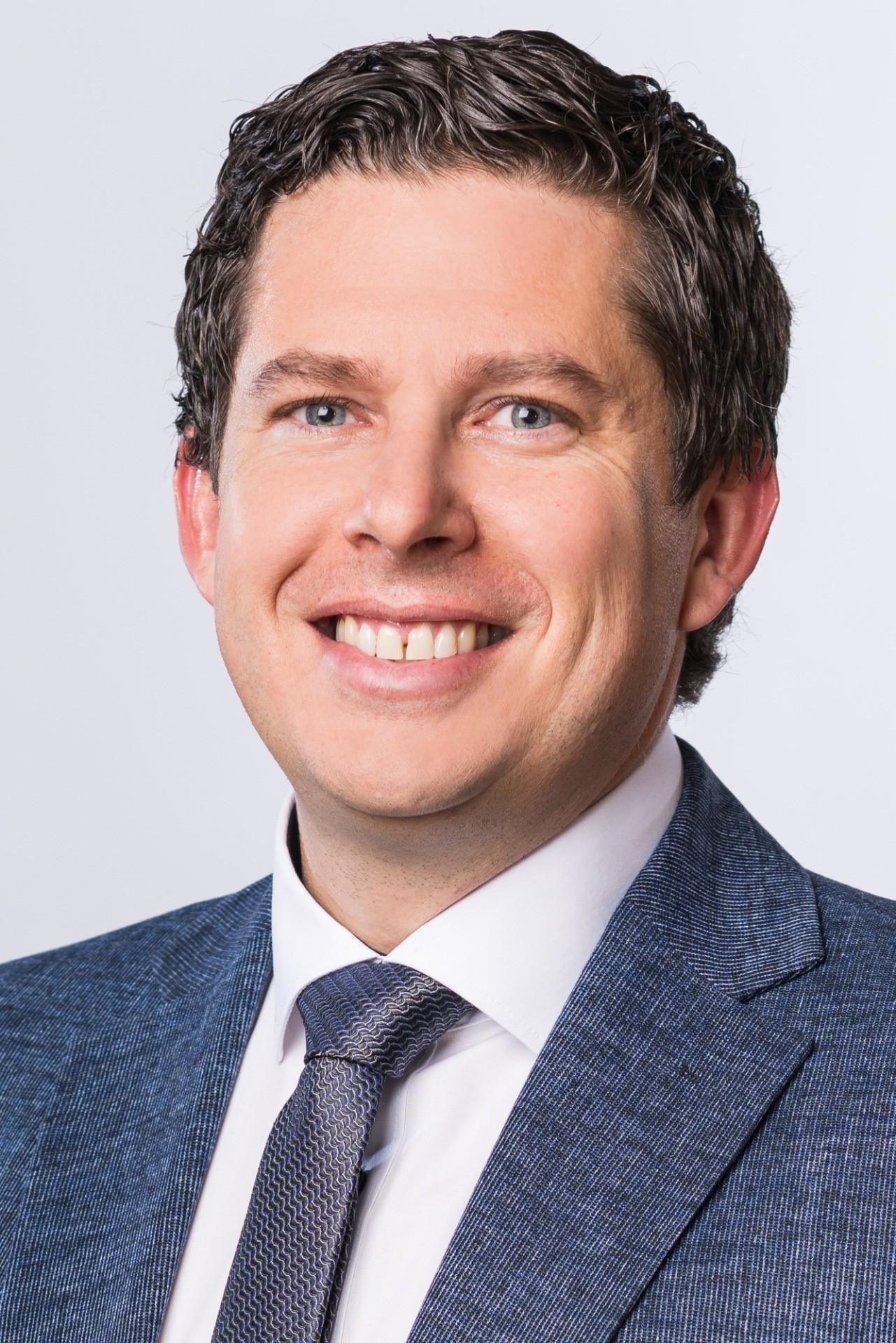 Lächeln des Mannes in Anzug und Hemd, dunkler Stoffhalskreis, vertikale Muster im Anzug.