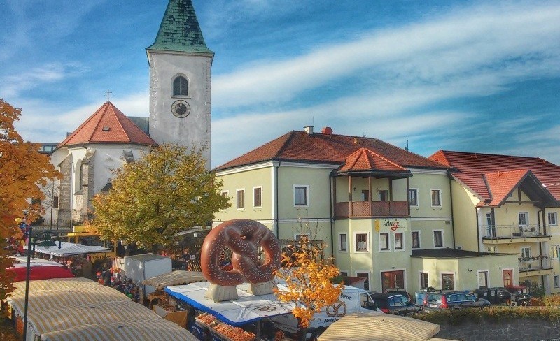 Altstadt mit Kirche und Brauerei, rote Dächer, Herbstlaub, Markt, große Brezel