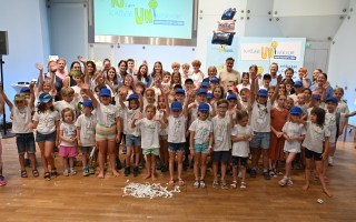Kinder feiern Geburtstag mit Kuchen und Geschenken. Viele Kinder in bunten Klamotten, Lächeln und Freude.