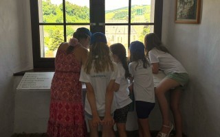 Kinder blicken auf ein steinernes Gebäude in der Ferne.