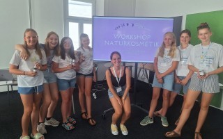 Mehrere Mädchen sitzen in einem Raum und nehmen an einem Workshop zum Thema Naturkosmetik teil.