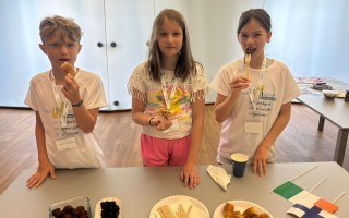 Eine junge Frau sitzt an einem Tisch mit einer Tasse und einigen Kuchenstücken.