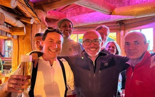 Gruppe von Menschen, die in einem Raum zusammen sitzen und Bier ausschenken.