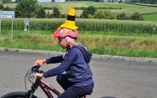 Radfahrerin auf Mountainbike auf Feldweg mit Warnweste und gelbem Warnweste.