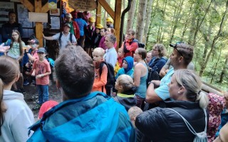 Versammlung von Menschen in einer Hütte. Kinder und Erwachsene stehen in einer Gruppe.