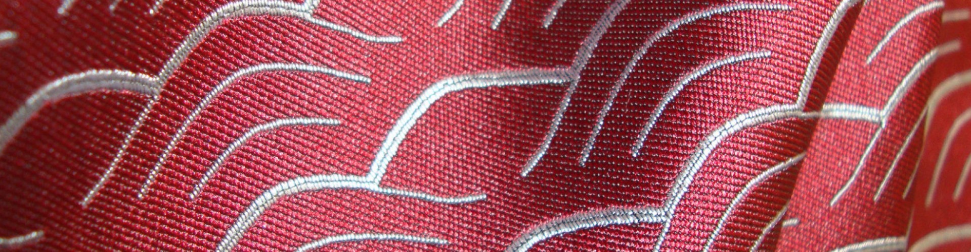 Roter Stoff mit feinen, weißen, geschwungenen Mustern. Nahtlose Textur.