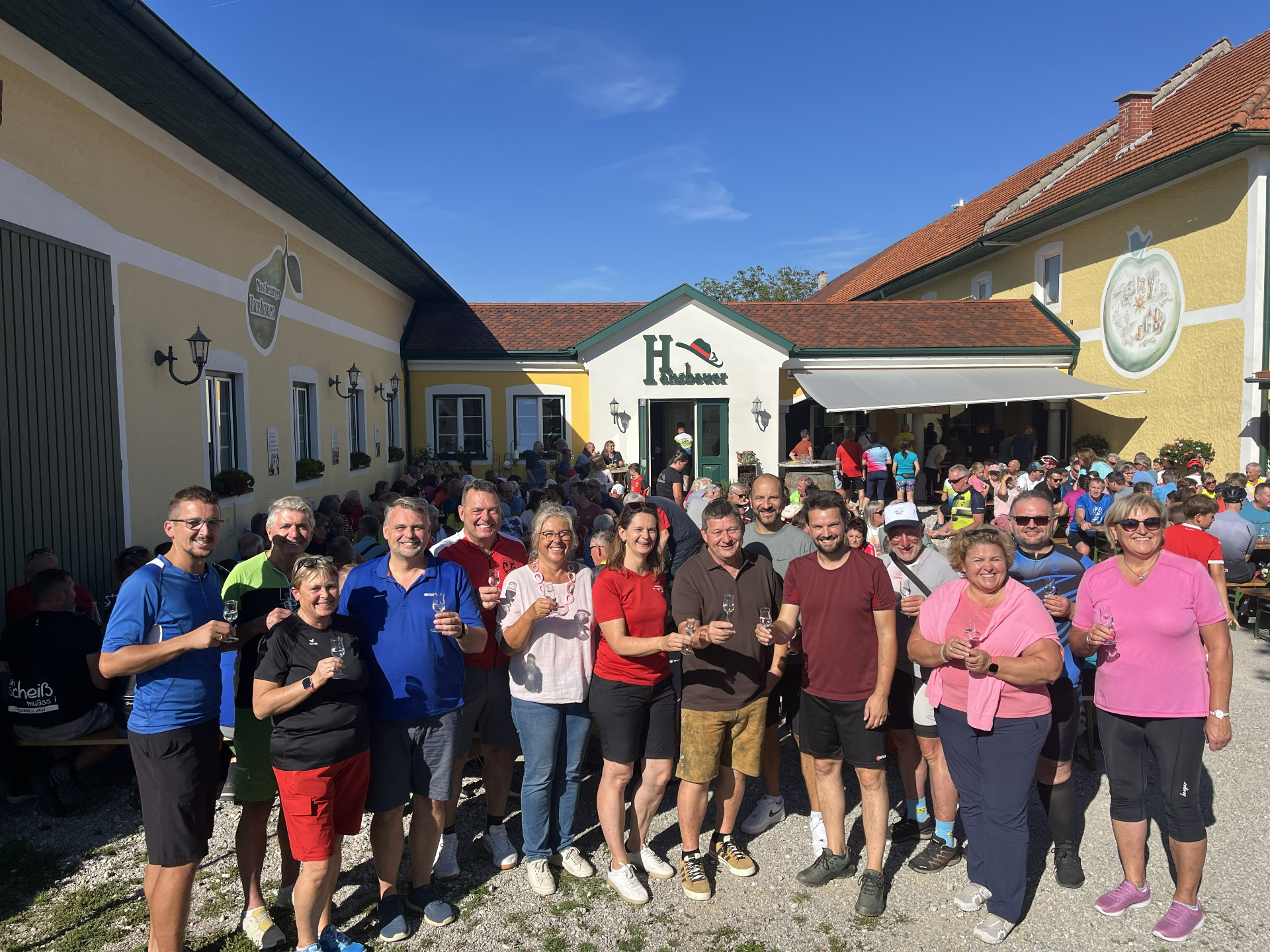 Gruppe von Menschen mit Gläsern vor dem Gasthof H. Haschauer in Niederösterreich