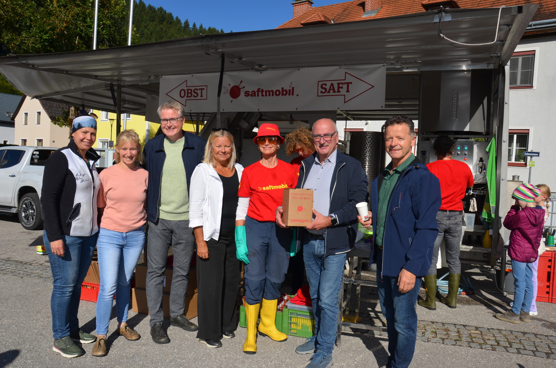 saftmobil-Team mit Besuchern vor einem Stand mit Obst- und Saftangeboten